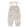 Baby wearing the Earthtone Floral organic muslin tie shoulder jumpsuit with ruffle trim and snap leg closure