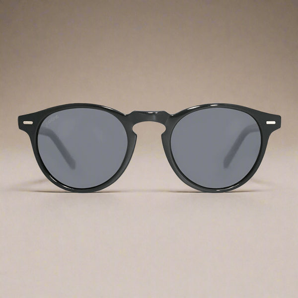 Black sunglasses with gray lenses on a beige background