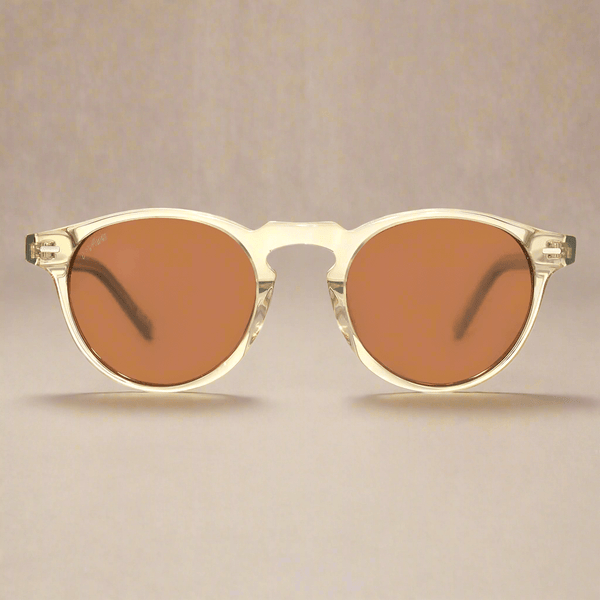 Sunglasses with gold frame and brown lenses on a beige background