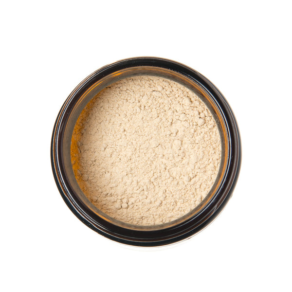 Beige powder in a black container on a white background