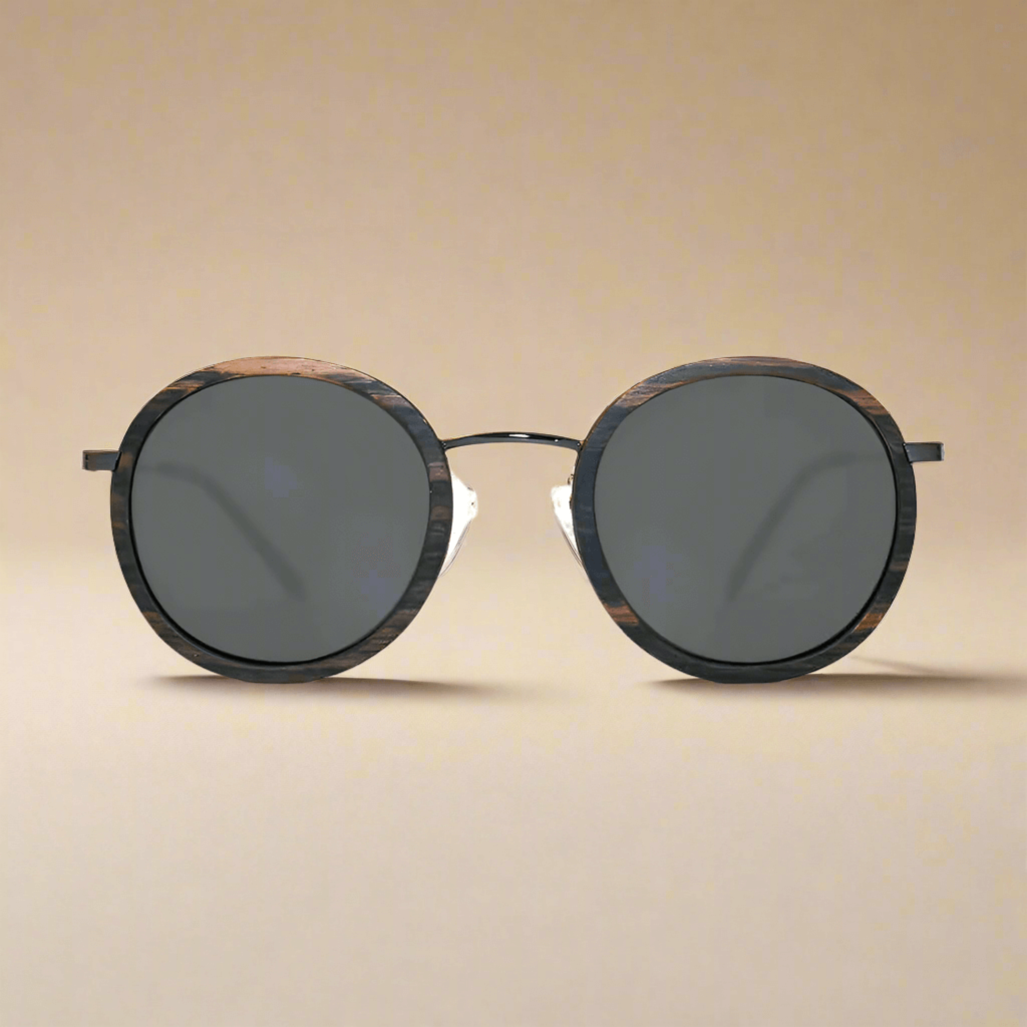 Round sunglasses with dark lenses on a beige background