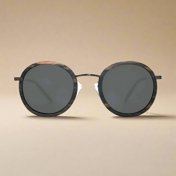 Round sunglasses with dark lenses on a beige background