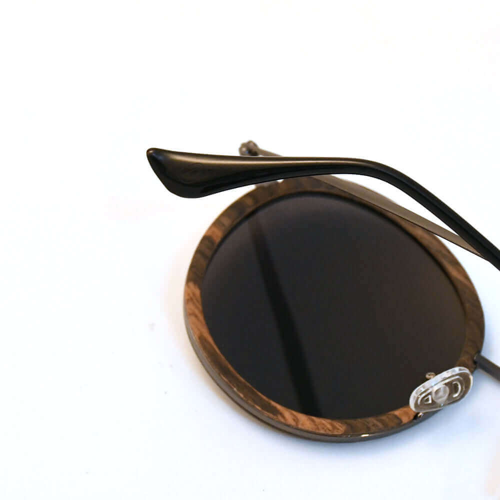 Round sunglasses with wooden frame and dark lenses on a white background