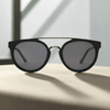 Black sunglasses with dark lenses on a light surface with a blurred background