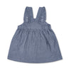 Close-up detail of organic chambray overall dress showing elastic waist and ruffle strap detail