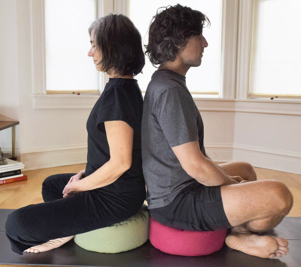 Couple meditating together on zafu meditation cushions with organic buckwheat hull filling