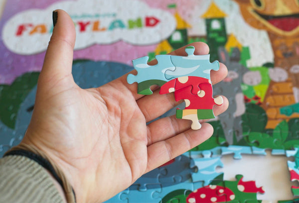 Close-up detail of the Children's Fairyland puzzle pieces showing ribbon-cut interlocking design and vibrant artwork by Greg Berger