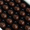 Close-up of chocolate truffles in a grid on a black tray