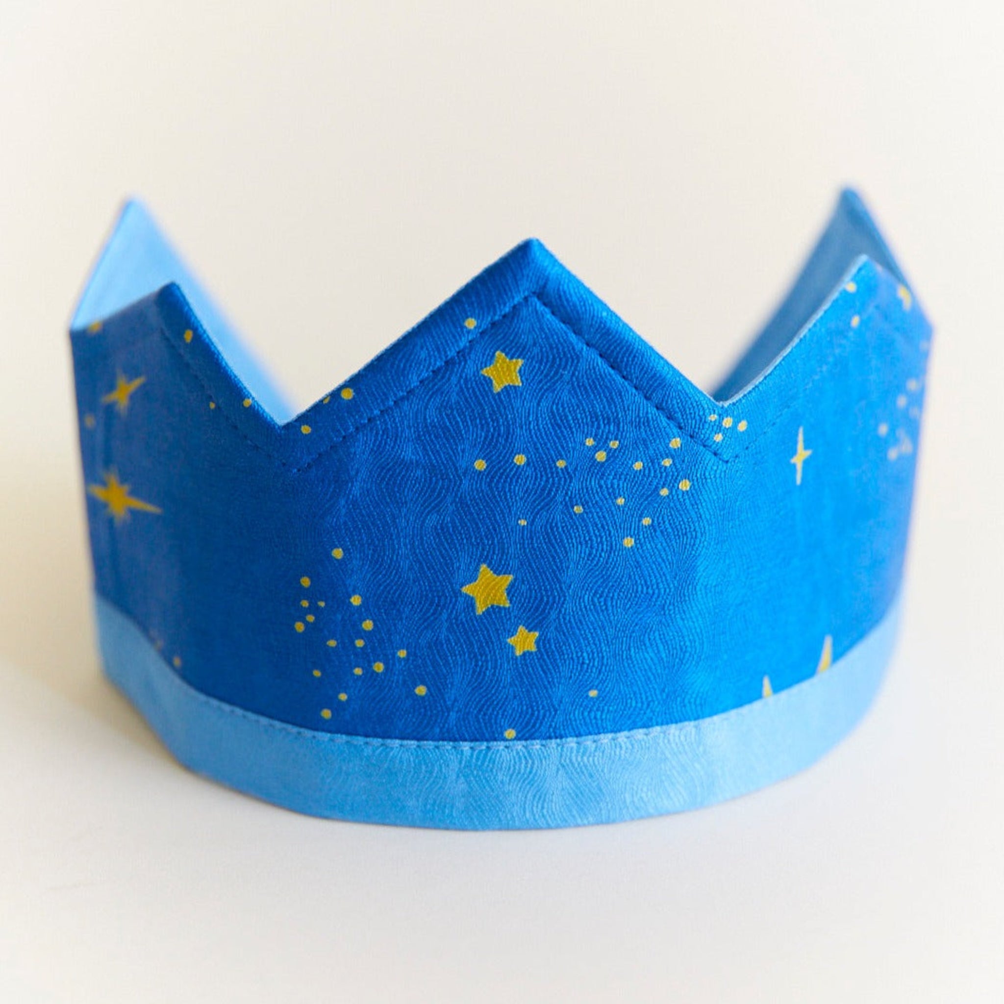 Blue paper crown with gold stars on a white background