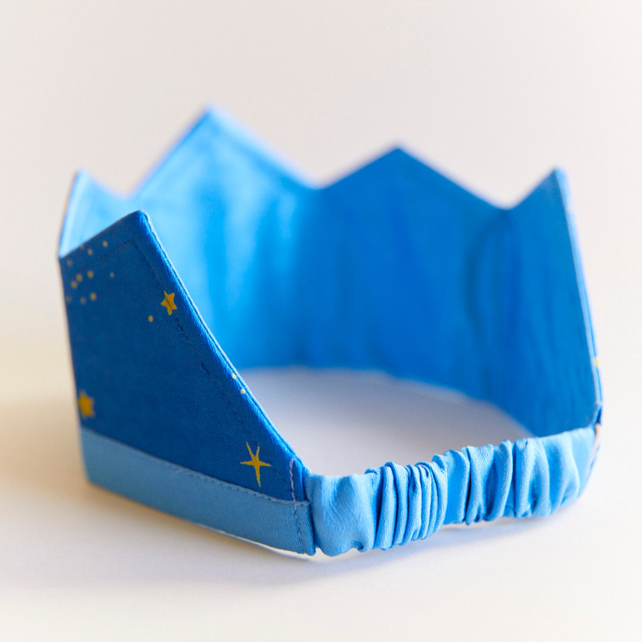 Blue crown with star patterns on a light background
