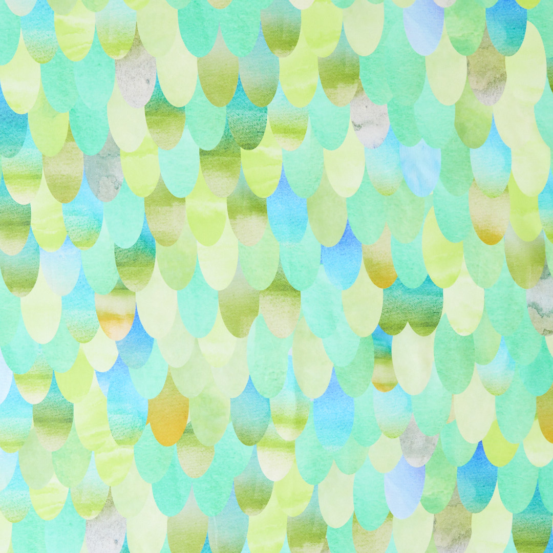 Pattern of watercolor droplets in green, blue, and yellow on a light background