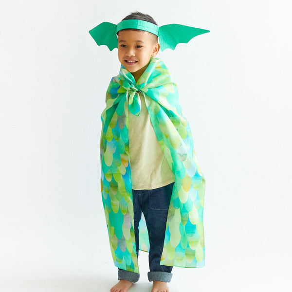 Child wearing a green and blue costume with wings on a white background
