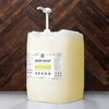 Large container of dish soap with a pump against a wooden background
