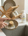 Rustic Strength lemon and eucalyptus liquid dish soap being used to wash dishes