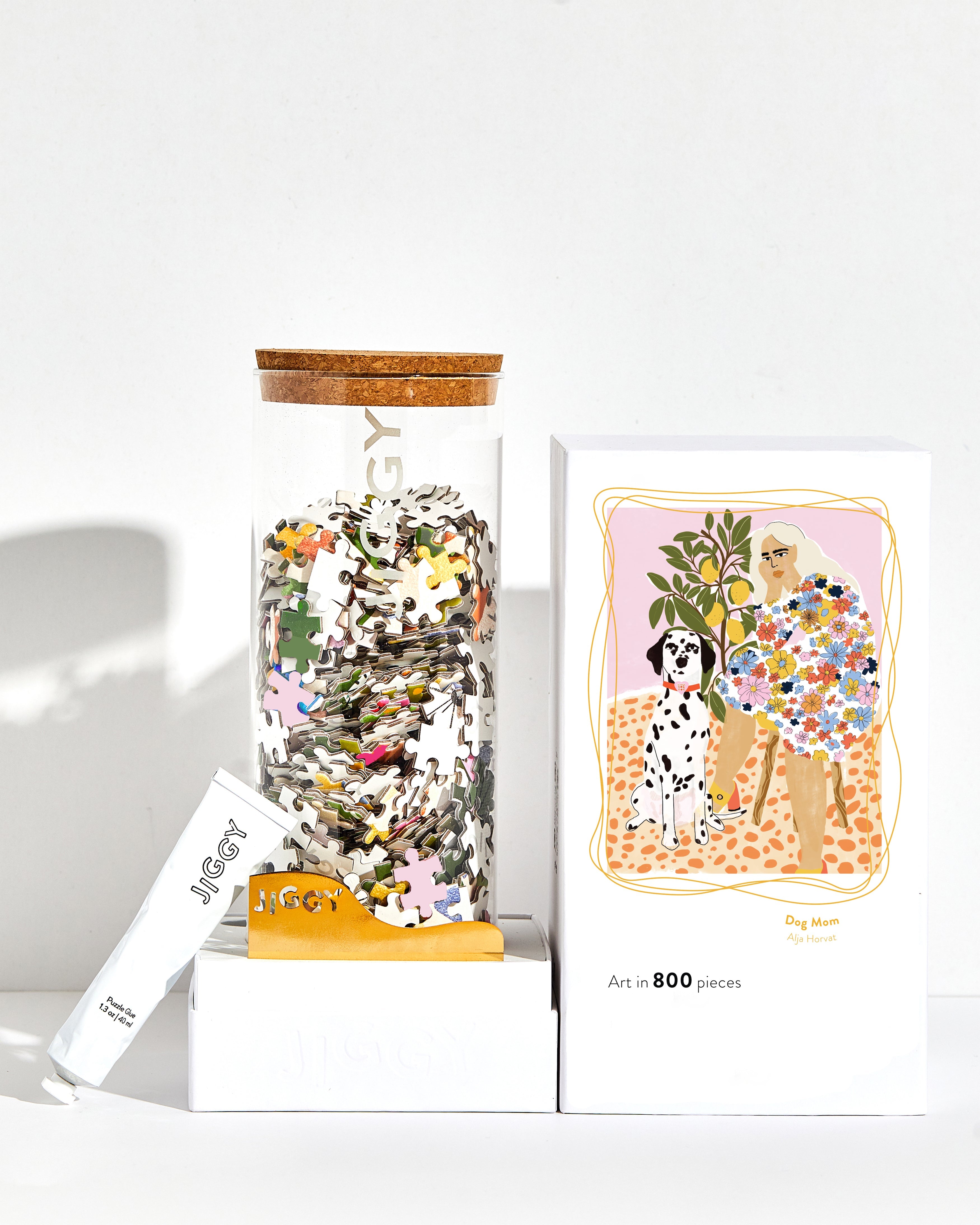Jigsaw puzzle jar, box, and Dalmatian-themed card on a white background