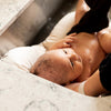 Newborn resting in the Little Dove Infant Sink Bather, showing secure contoured fit inside a kitchen sink