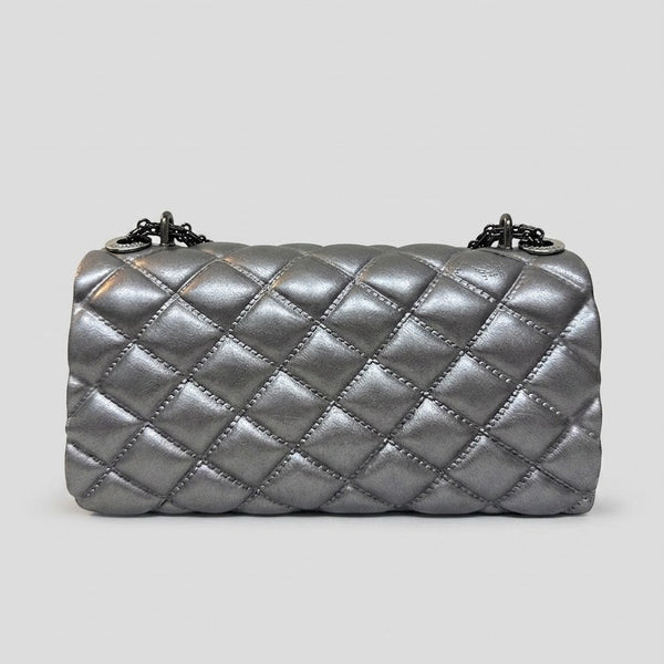 A metallic silver quilted shoulder bag with a diamond pattern and a chain strap, shown against a solid light gray background.