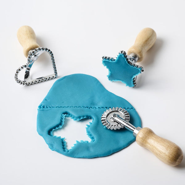 Set of cookie cutters with blue fondant on a white background