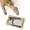 Dinosaur toy with a box of eco-kids dinosaur bones crayons on a white background