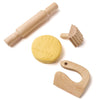 Set of wooden kitchen tools including a rolling pin, yellow mold, and other shapes on a white background.