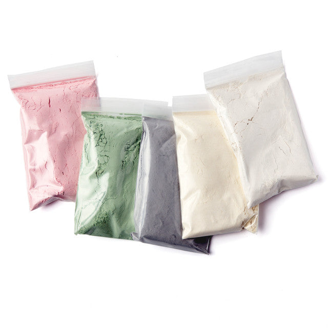 Four bags of different colored powders on a white background