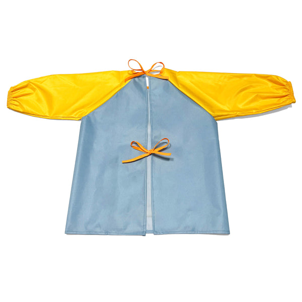 Young child in a long-sleeve art smock painting at a table, clothes fully protected from mess