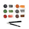 Natural earth watercolor paint samples and brushes laid out on a white background