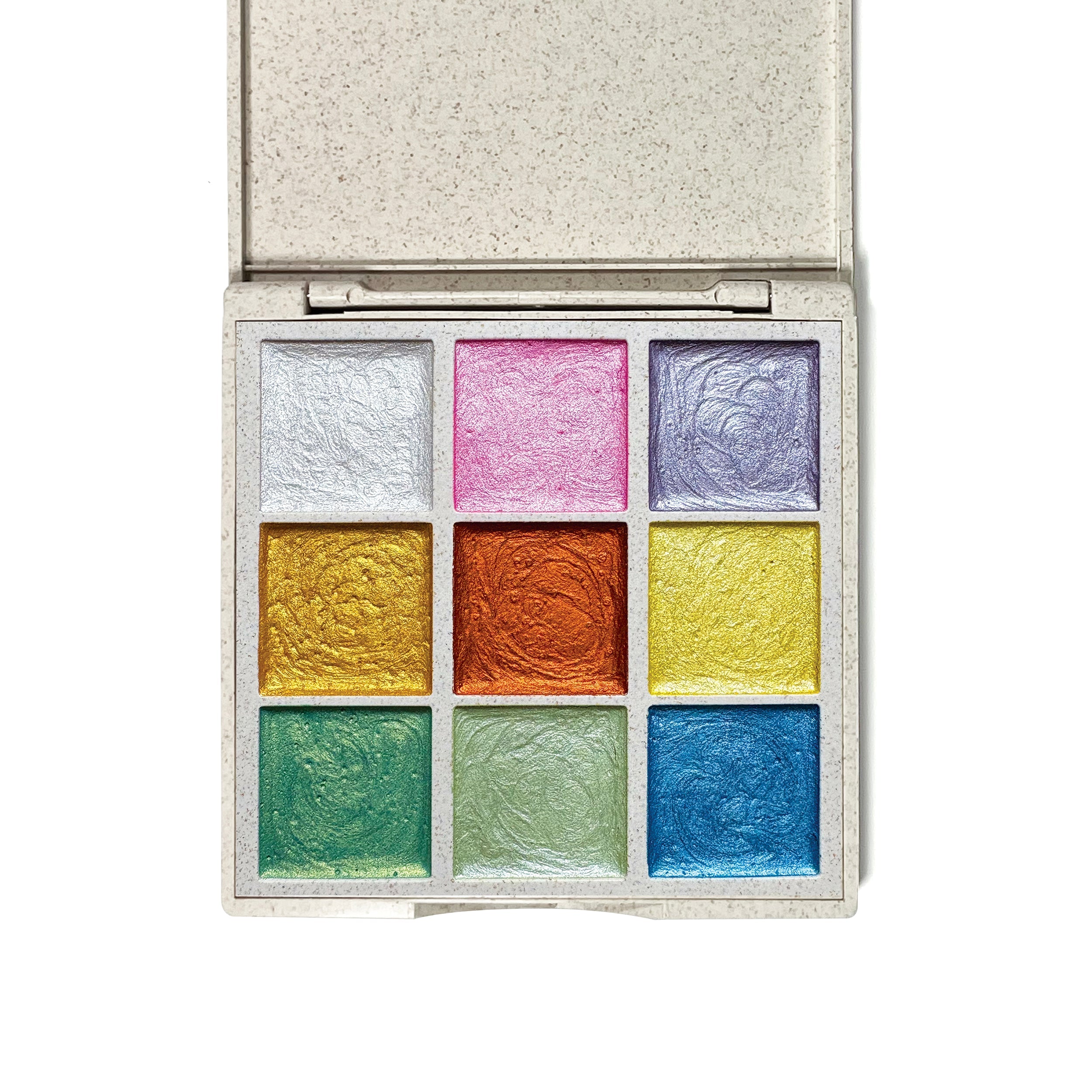 Close-up of hand-poured metallic watercolor pans showing shimmering pigment colors