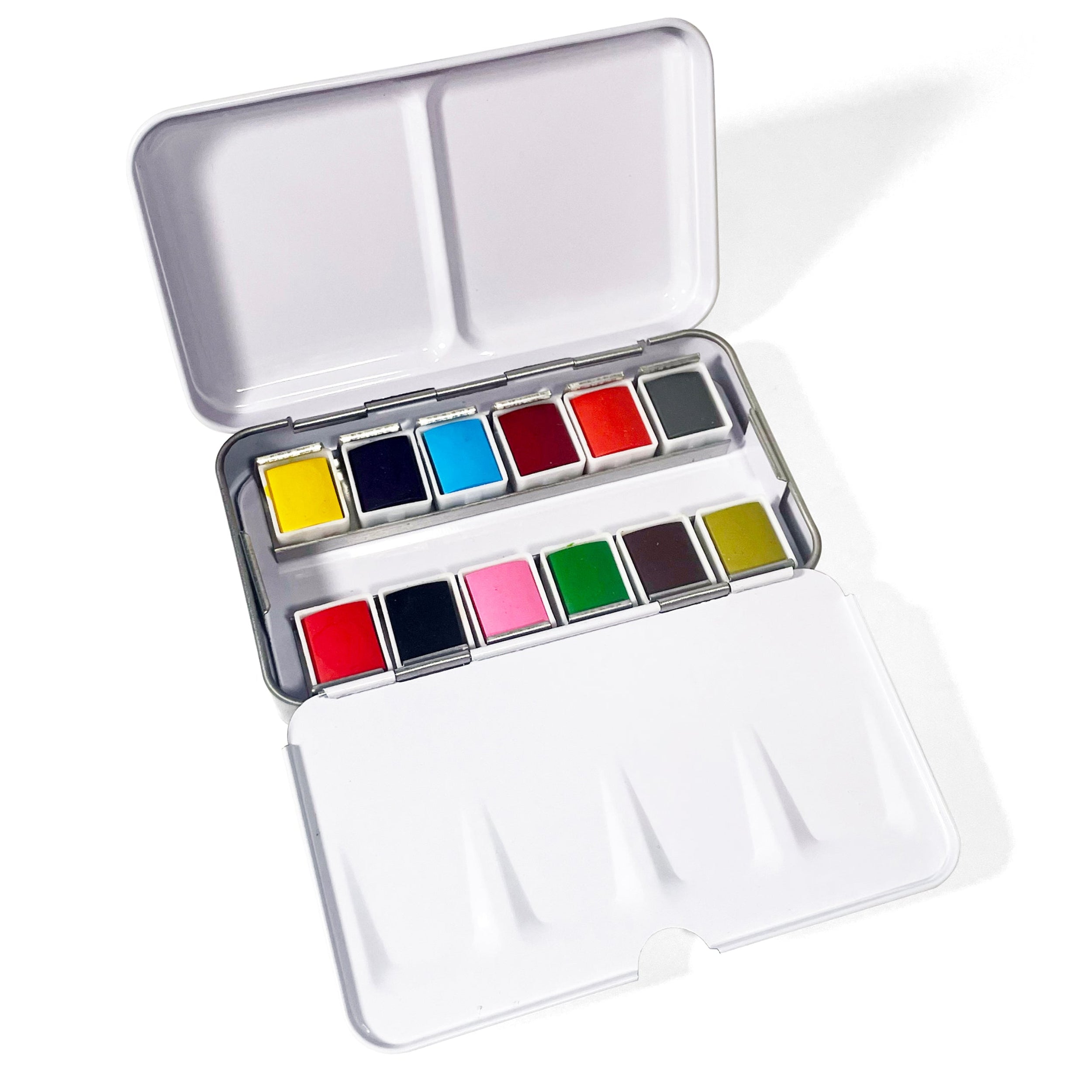Travel-friendly 12-color watercolor metal palette next to a paintbrush, perfect for plein air painting