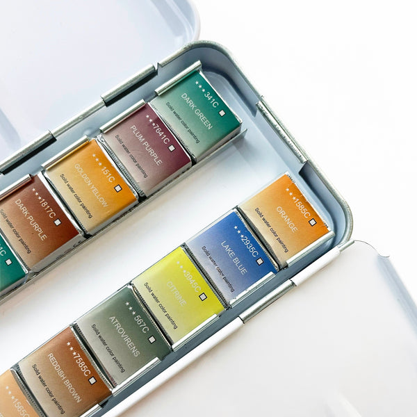 Elseware Unplug watercolor paint set in aluminum case shown with painted color swatches on paper