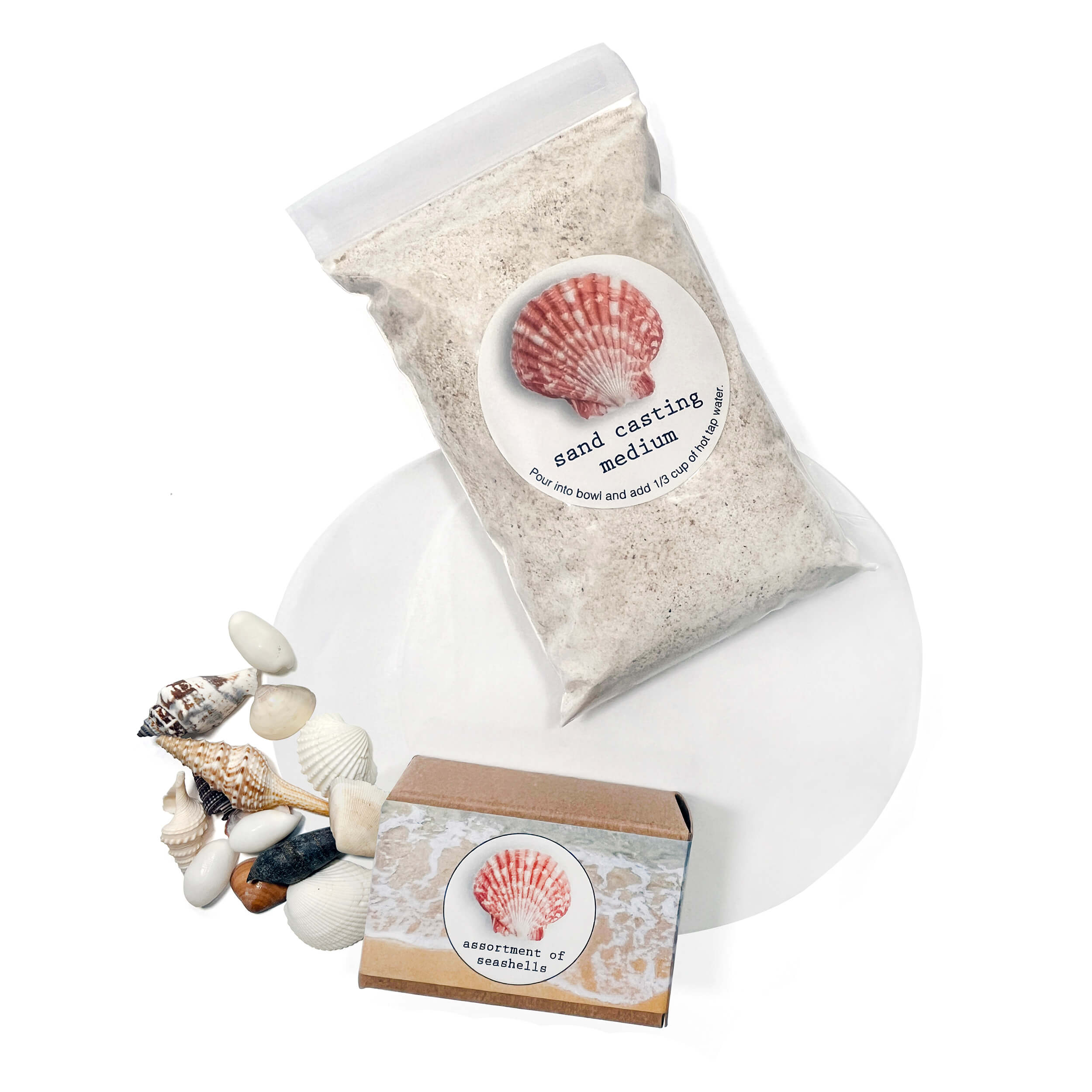 Bag of sand casting medium with a small box and seashells on a white background