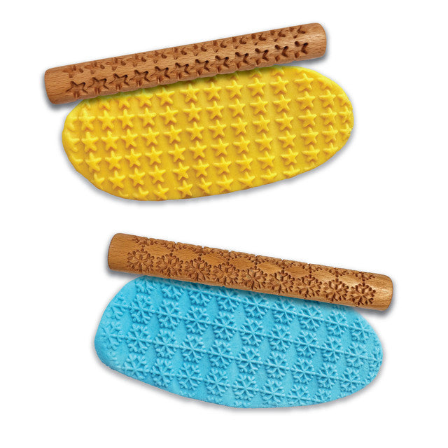 Two wooden rolling pins with star and snowflake patterns on a white background
