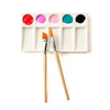 Paint palette with colorful paint samples and two brushes on a white background