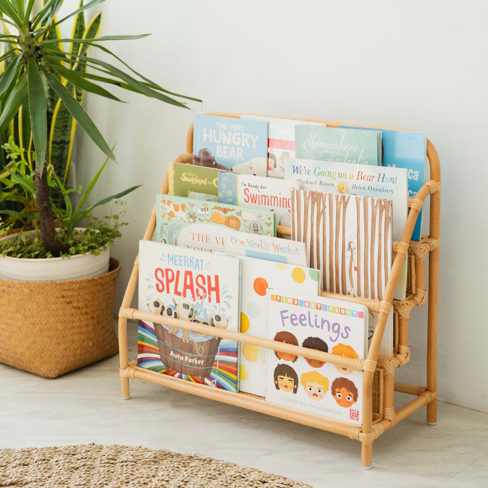 Elena Kids Rattan Montessori Bookshelf styled in a child's room with plants, rug, and front-facing children's books on display