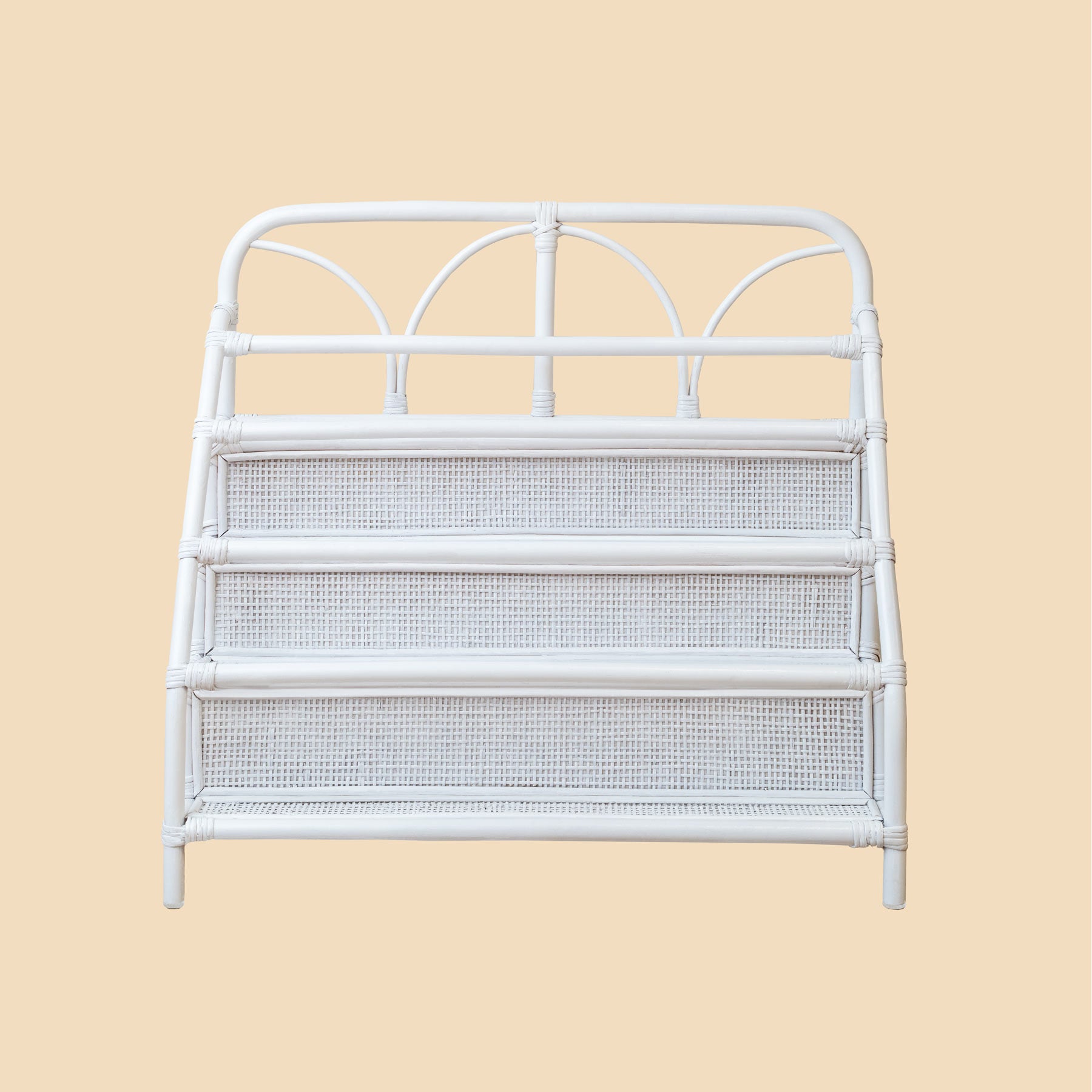 White metal headboard with wicker storage shelves on a beige background