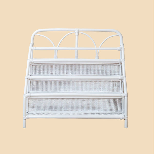White metal headboard with wicker storage shelves on a beige background