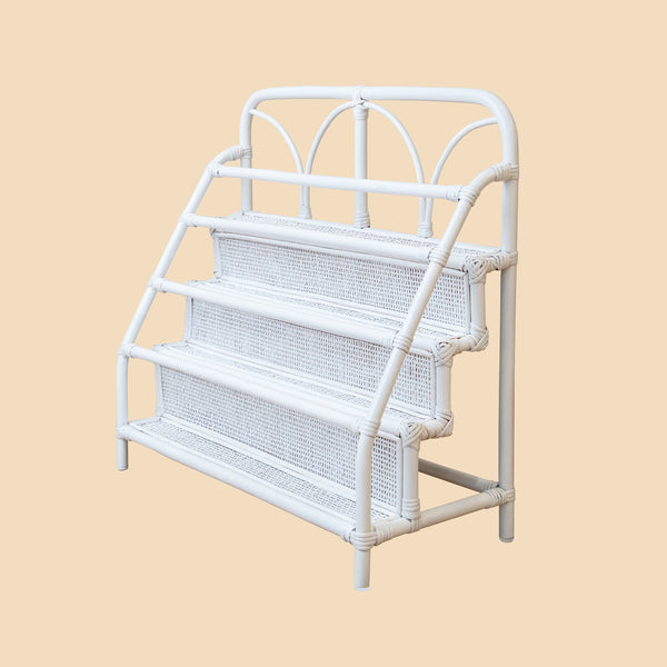 White wicker magazine rack on a beige background