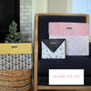 Stack of patterned folders on a shelf with decorative items in the background