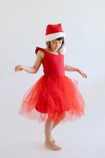 Child wearing a red dress and Santa hat on a white background