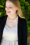 Fair Anita crescent hoop earrings worn as an everyday accessory, brass and black finish