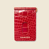 Red crocodile pattern cardholder with 'CASUPO' branding on a beige background