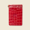 Red crocodile-patterned cardholder on a beige background