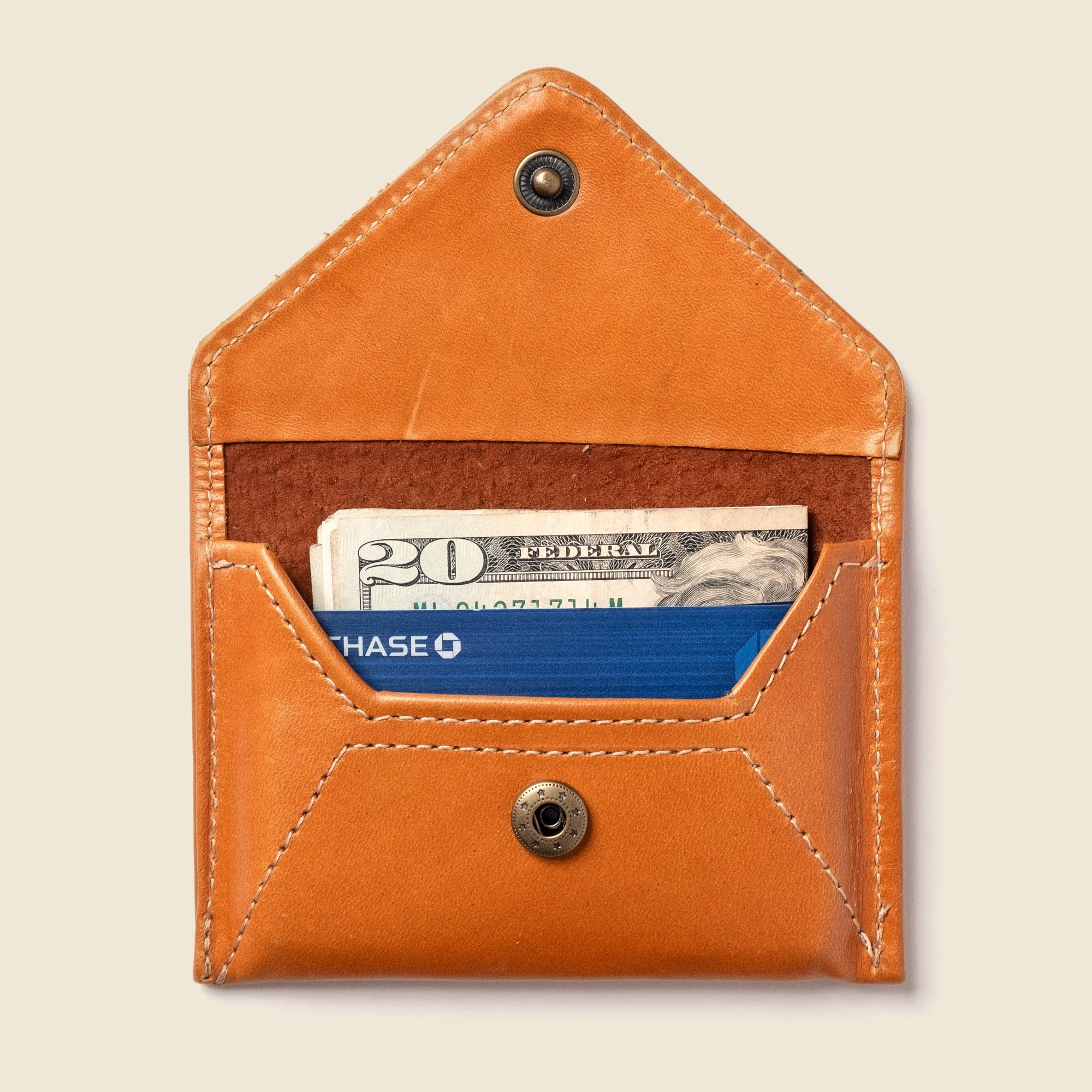 Shop the Mini Envelope Wallet in glossy honey leather with RFID protection. Handcrafted from upcycled leather in California—compact, secure, and eco-friendly.