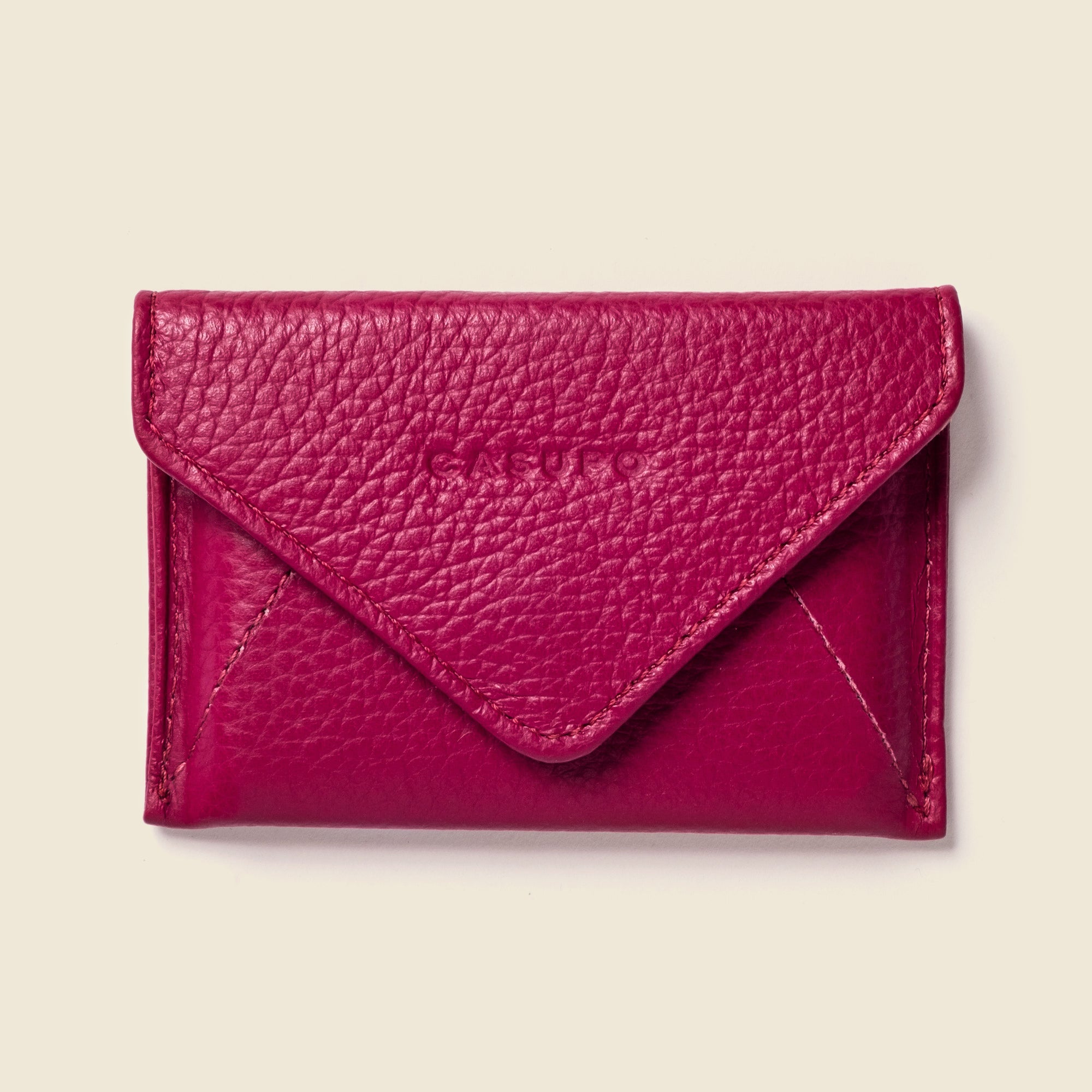 Pink leather wallet on a beige background