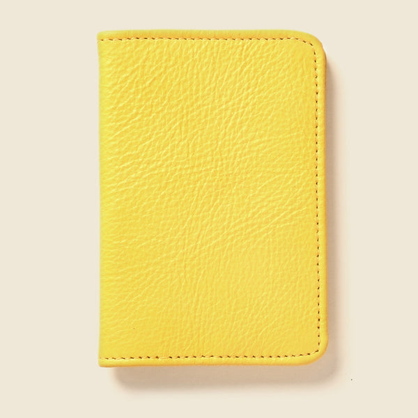 Yellow leather wallet on a beige background