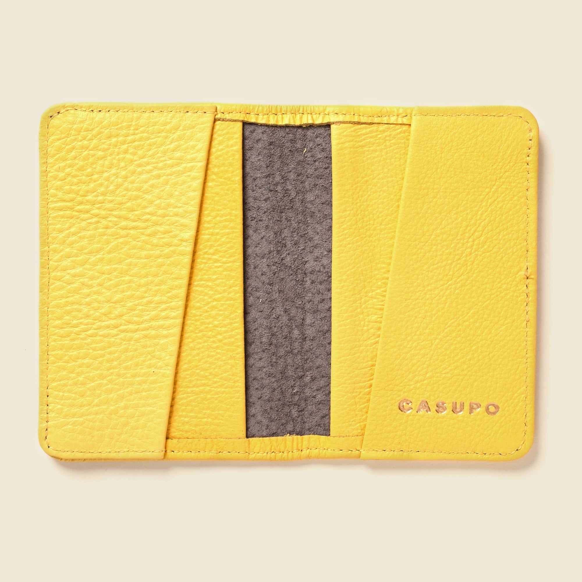 Yellow cardholder with a gray pocket on a beige background
