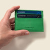 Green cardholder with Chase cards inside, held by a hand against a beige background