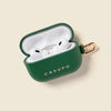 Green Casupo case with white wireless earbuds on a beige background