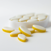 White and yellow oval tablets on a white background