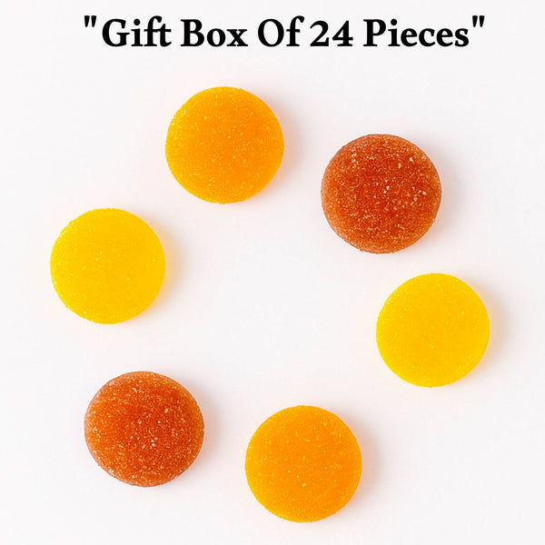 Orange and yellow gummy candies on a white background with text 'Gift Box Of 24 Pieces'.